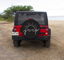 A Jeep Sun and Wave Tire Cover fitted on the rear of a vehicle, with a beach and vegetation in the background.